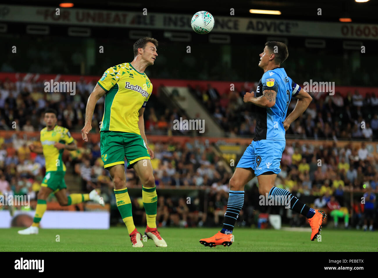 Carrow Road, Norwich, Regno Unito. 14 Ago, 2018. Carabao Calcio Coppa del primo round, Norwich City rispetto a Stevenage; Christoph Zimmermann di Norwich City capi la palla oltre Alex Revell di Stevenage Credito: Azione Sport Plus/Alamy Live News Foto Stock