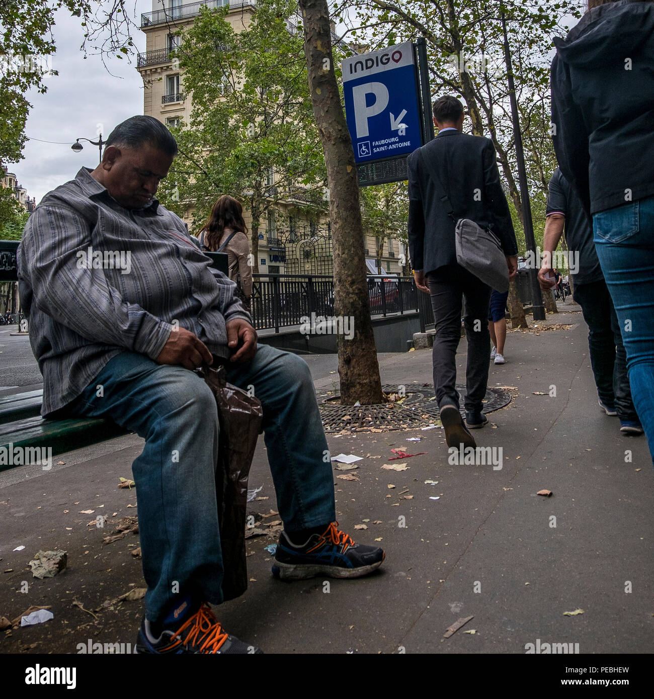 L'uomo addormentato su un banco di lavoro a Parigi, Francia Foto Stock