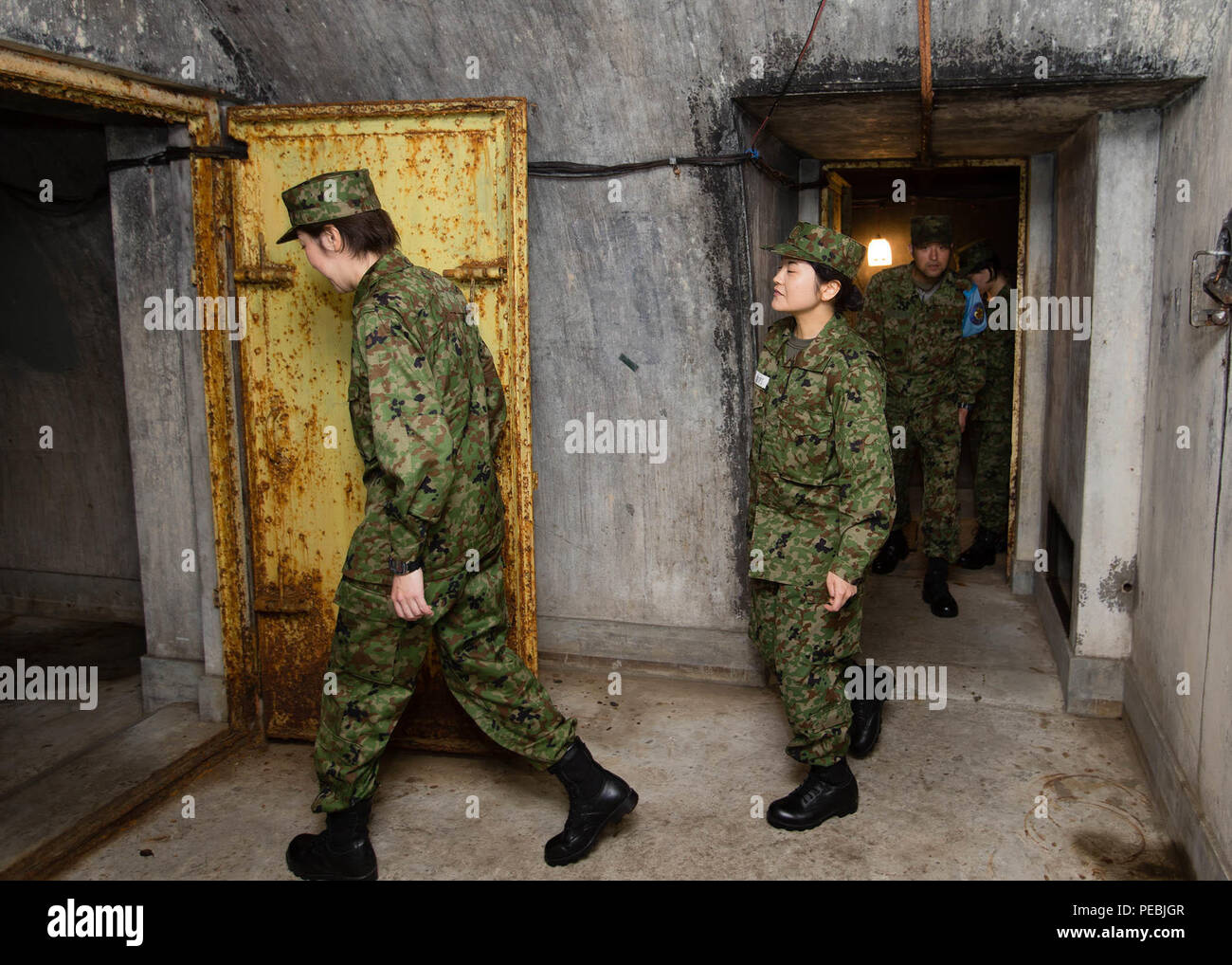 Durante una nov. 19, 2015, tour a piedi di Camp Zama, Giappone Giappone terra Forza di Autodifesa (JGSDF) Componente di riserva dei candidati dal JGSDF's 117Battaglione di formazione a piedi attraverso un raid aereo riparo costruito negli anni Trenta del Novecento e progettato specificamente per proteggere il Giappone imperatore da bombe e shrapnel. Stati Uniti Esercito il Giappone e l'unità JGSDF con sede a Camp Zama lavorano insieme per preservare le Air Raid Shelter e altri punti di riferimento che distinguono il post è fiero passato. (U.S. Foto dell'esercito da Imada Yuichi, U.S. Esercito Garrison-Japan) Foto Stock