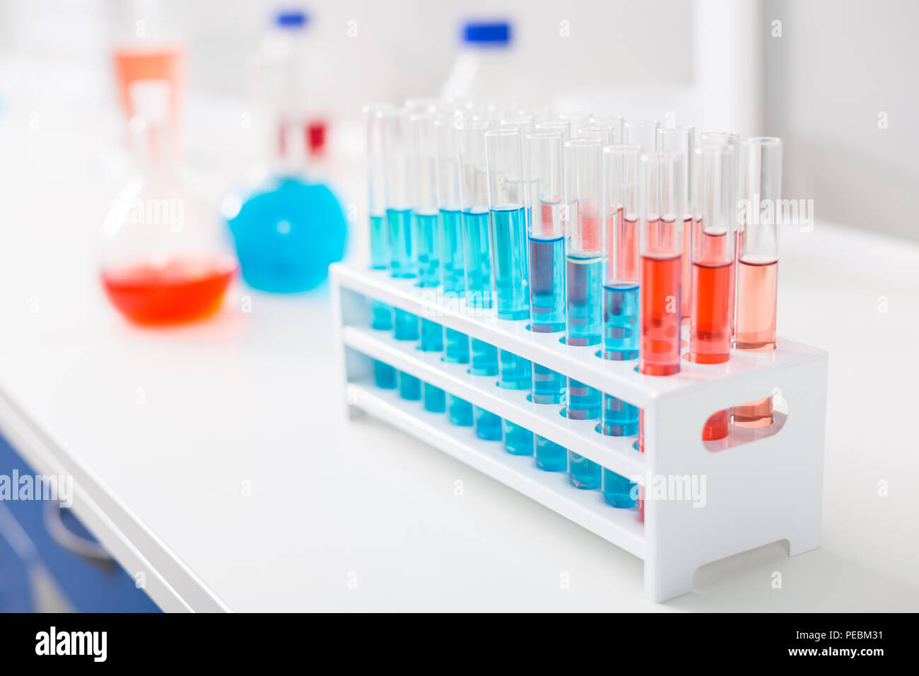 Ordine di eccellente. Trasparente molti piccoli flaconcini messa in stand che permanente sulla superficie Foto Stock