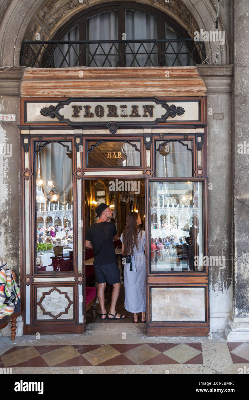 Turista giovane in piedi la porta del Caffè Florian e Piazza San Marco, San Marco, Venezia, Veneto, Italia, inaugurato nel 1720 è il più antico Cafe nel Foto Stock
