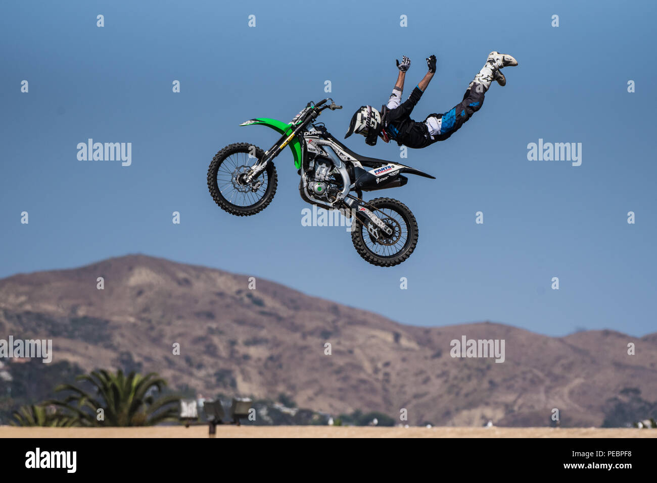 Stunt rider in costume nero vola in midair su moto con le braccia distese sul salto durante battenti U Rodeo a Ventura County Fair su agosto 12, 2018 in cal Foto Stock