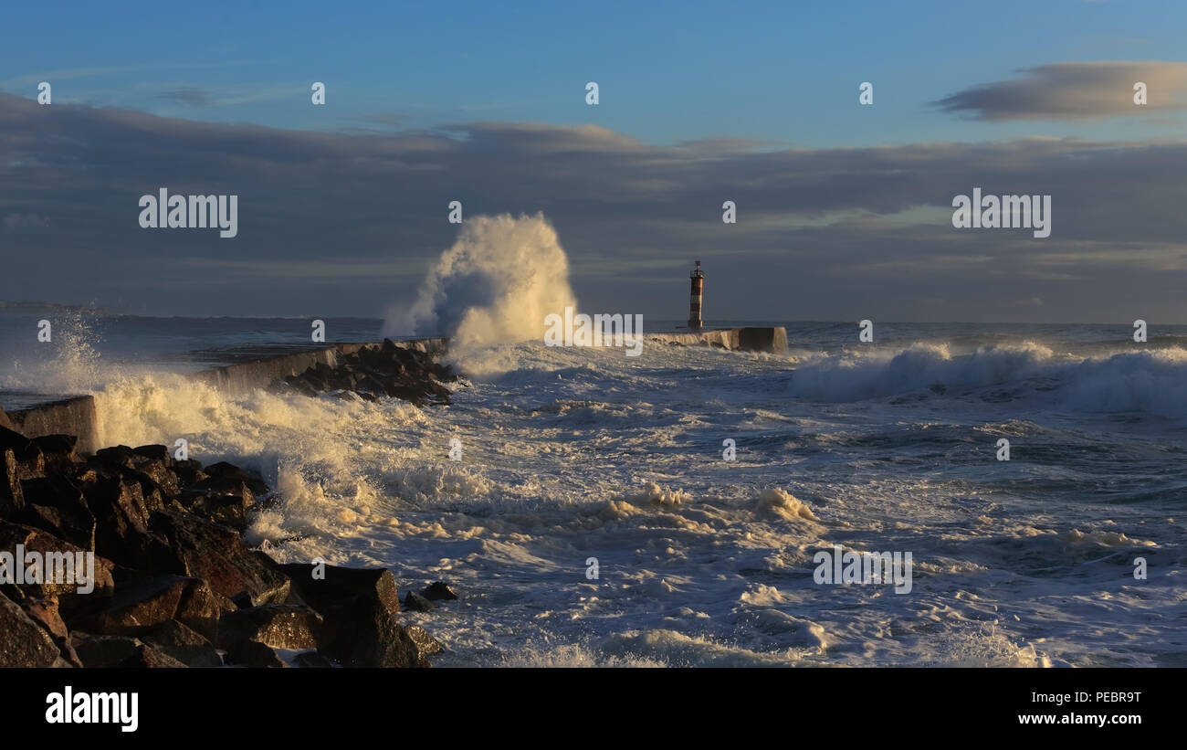 Tempesta di mare al tramonto nel nord della costa portoghese Foto Stock