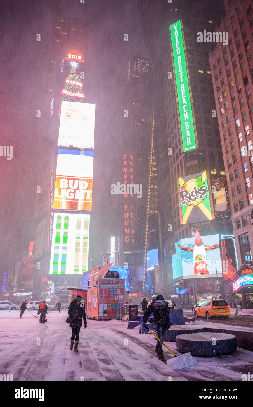La gente a piedi attraverso Times Square su un snowy mattina presto durante la tempesta di neve Grayson nel gennaio 2018. Foto Stock