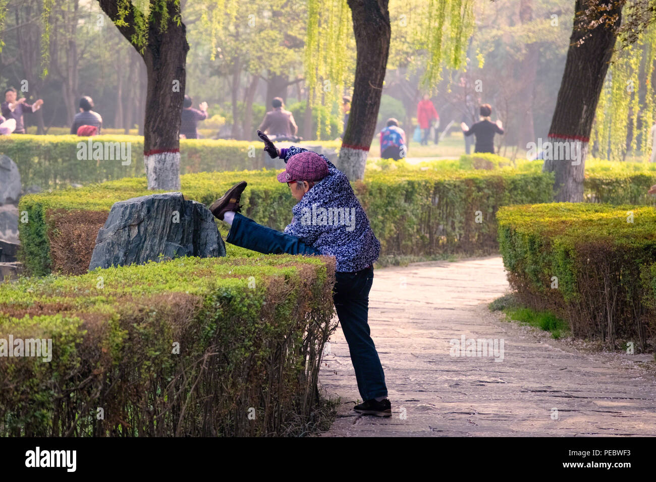 Anziani donna cinese Stretching nel Parco XinJinYuan, Xian, Cina Foto Stock