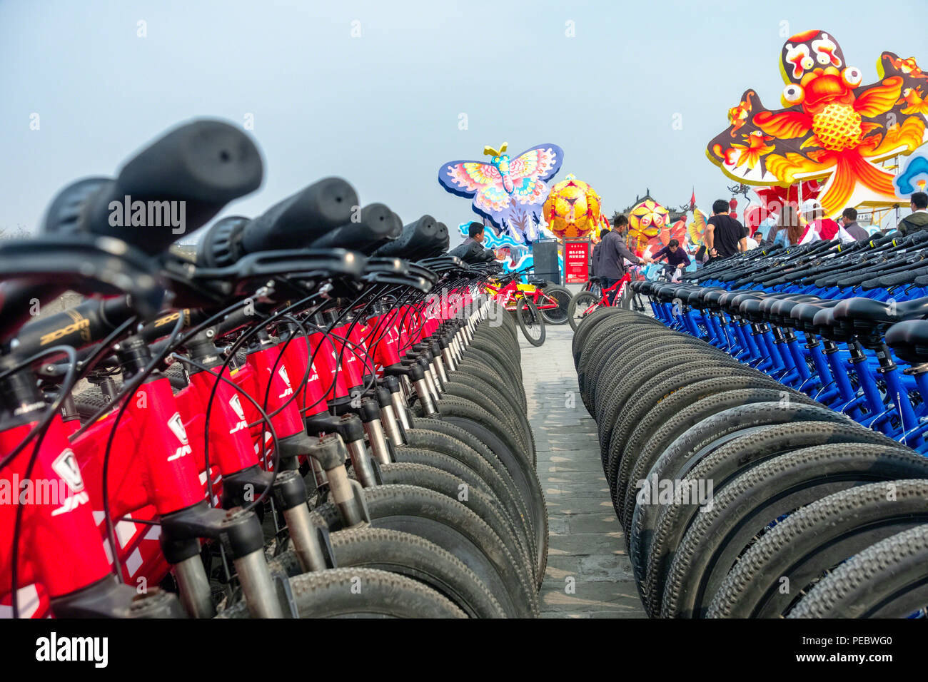 Righe del Noleggio City Bike sulla parete della città, Xi'an, Provincia di Shaanxi, ChinaChina Foto Stock