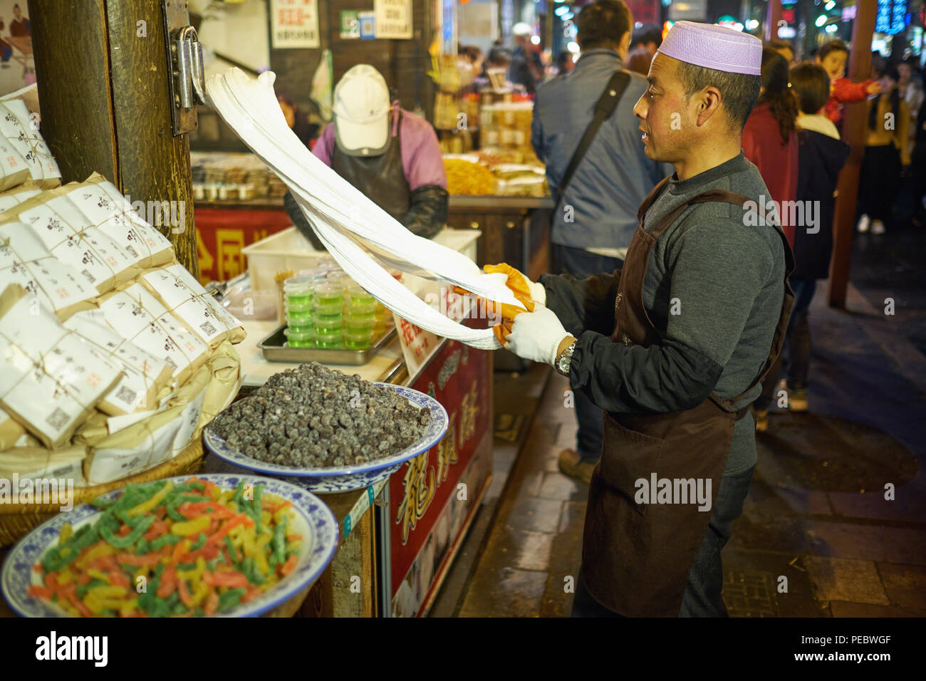 Un uomo lo stiramento impasto in un mercato all'aperto, Musulmana Street, Xian, Shaanxi, Cina Foto Stock