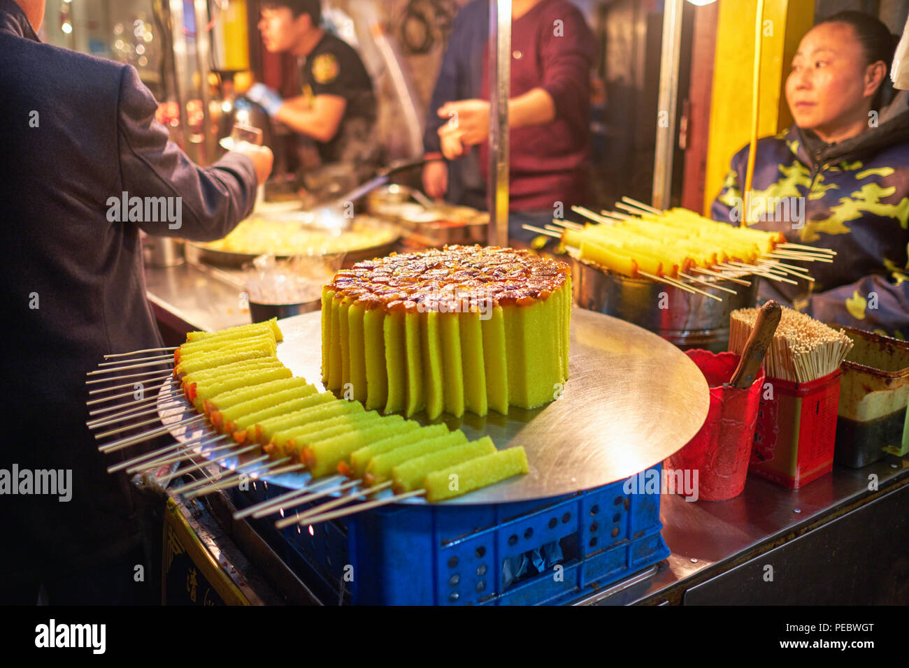 Torta di riso con date le caramelle su un bastone visualizzati in corrispondenza di un venditore ambulante, Xi'an, Cina Foto Stock