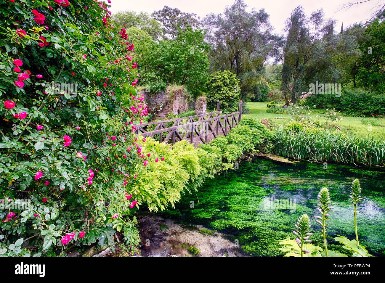 Passerella di piccole dimensioni su un torrente in una ninfa giardino, Cisterna di Latina, Italia Foto Stock