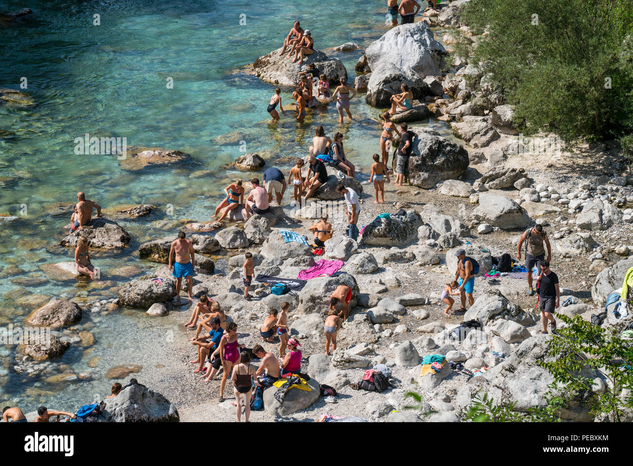 La gente che prende il sole e fare il bagno nel fiume Soca in estate in Kobarid, Slovenia Foto Stock