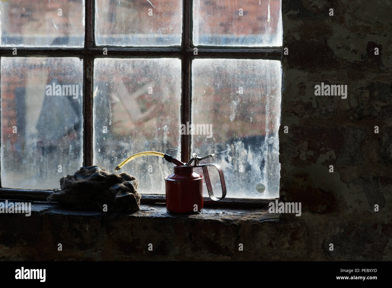 Vecchio ripiano di vetro in una fabbrica abbandonata con olio può REGNO UNITO Foto Stock