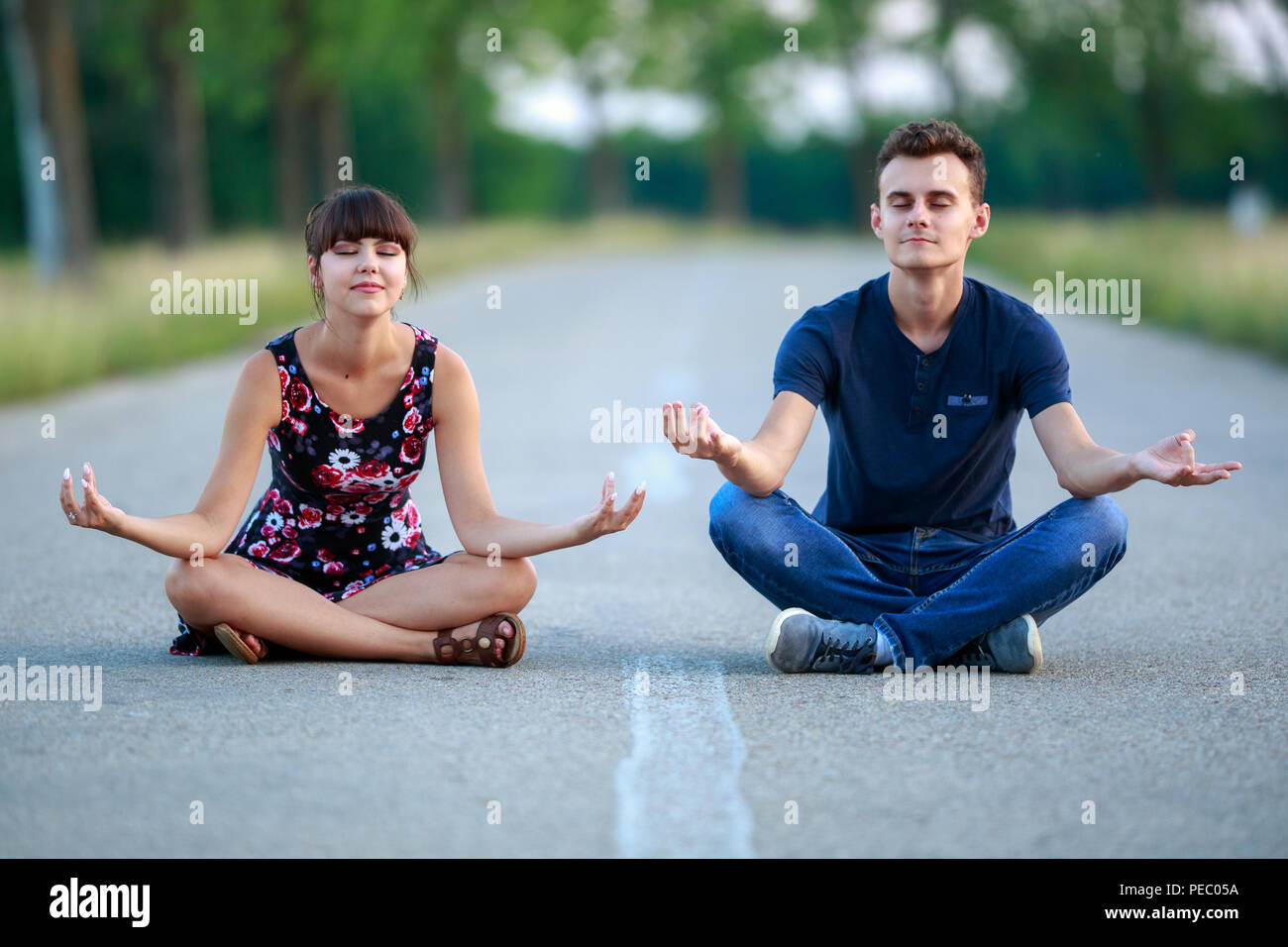 Unconventional matura in postura di yoga in mezzo alla strada Foto Stock