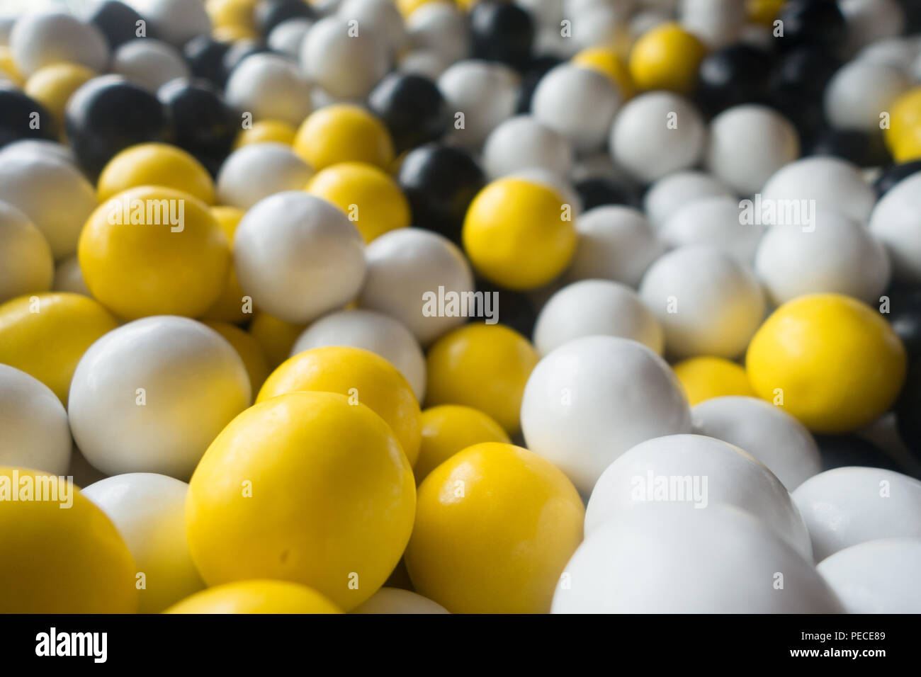 Molti nero, bianco e giallo gumballs Foto Stock
