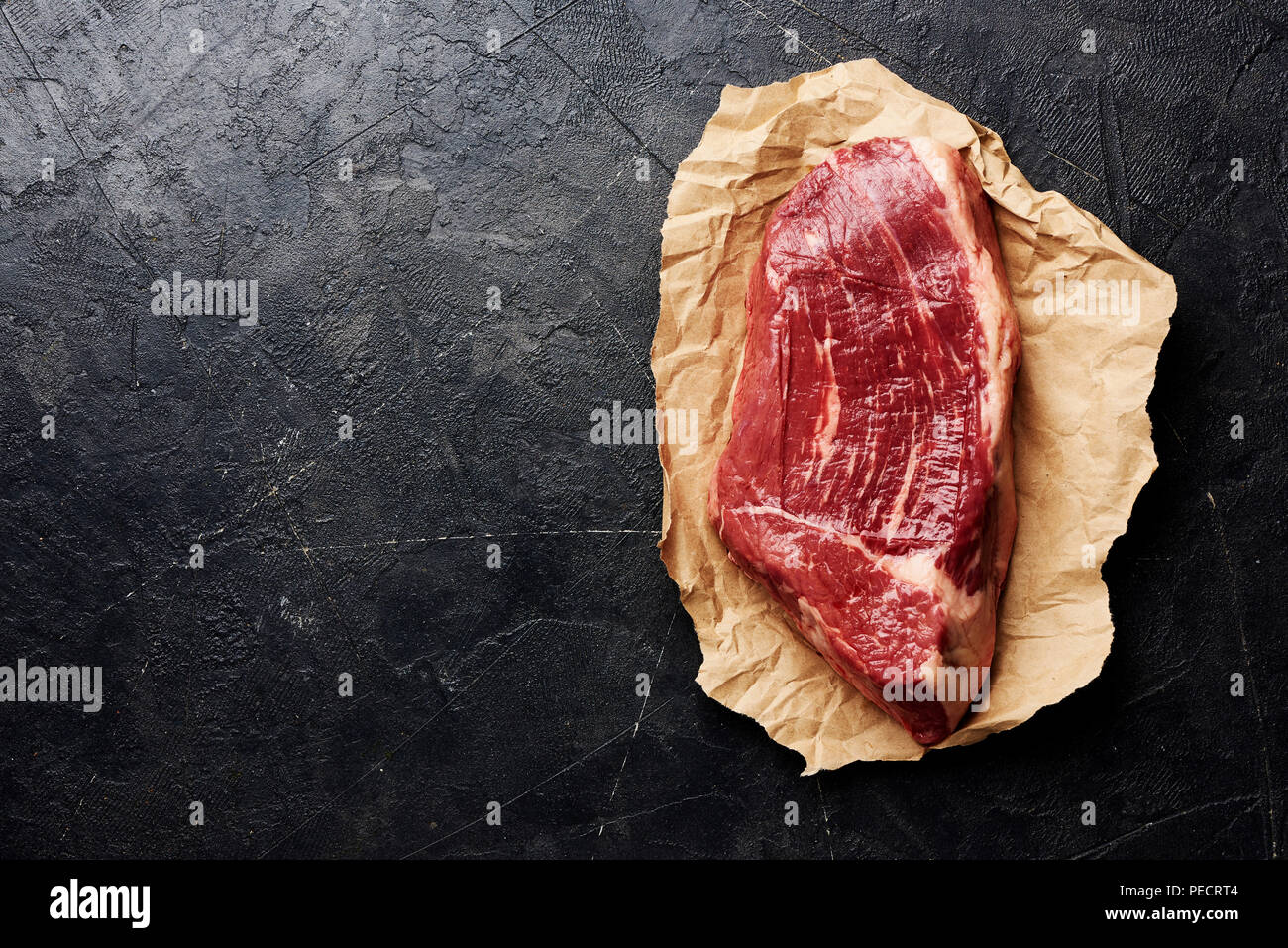 Crudo fresco di carne in marmo nero bistecca angus su sfondo nero con copia spazio. Vista dall'alto. Foto Stock