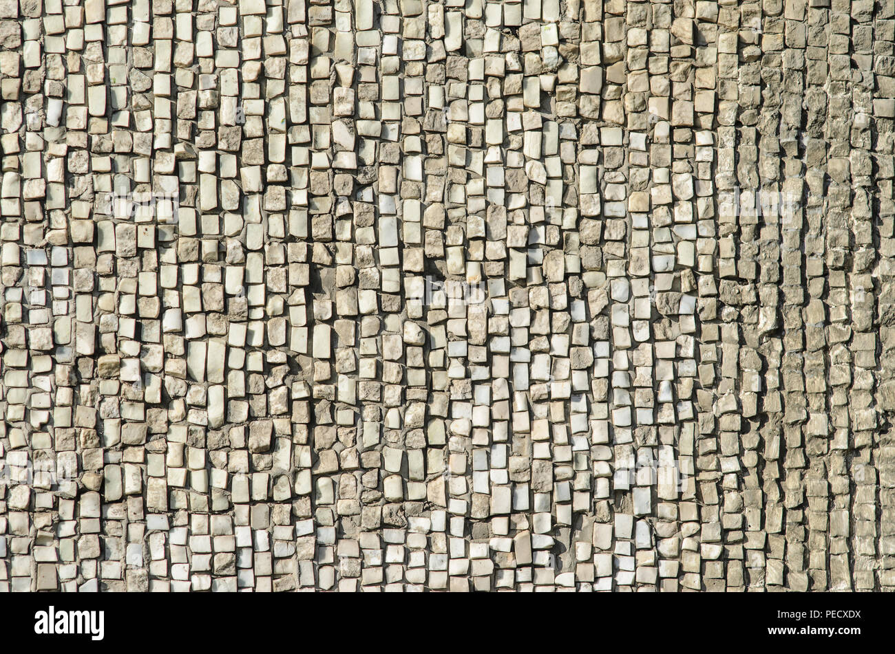 Vecchio weathered mosaico pietra texture. Parete naturale materiale di finitura Foto Stock