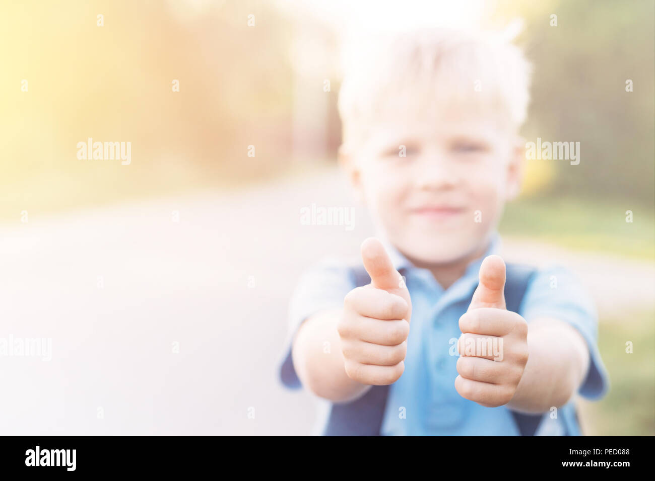 Ragazzo Chherful dà un pollice in su. Scolaro ama l'istruzione. Foto Stock