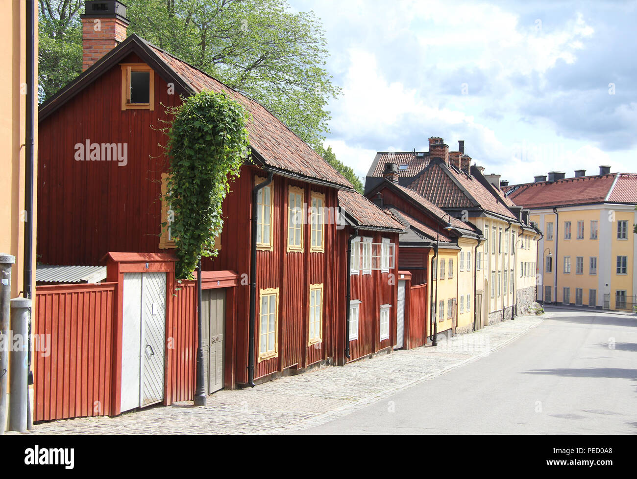 Strada con case di legno dipinte di rosso e sull'isola di Södermalm, Stoccolma Svezia Foto Stock