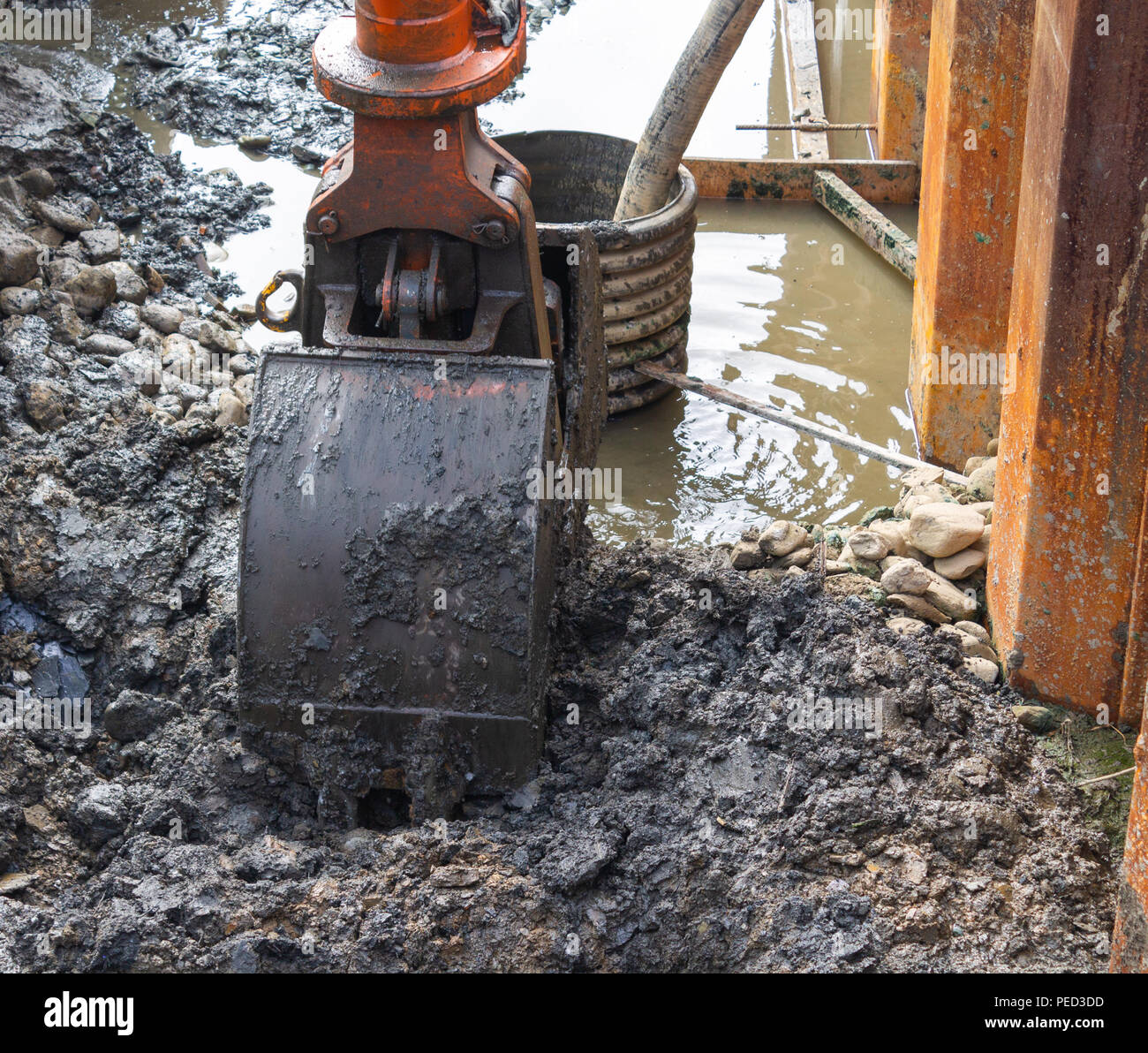Escavatore - benna con lo scavo di una trincea su un sito di costruzione. Foto Stock