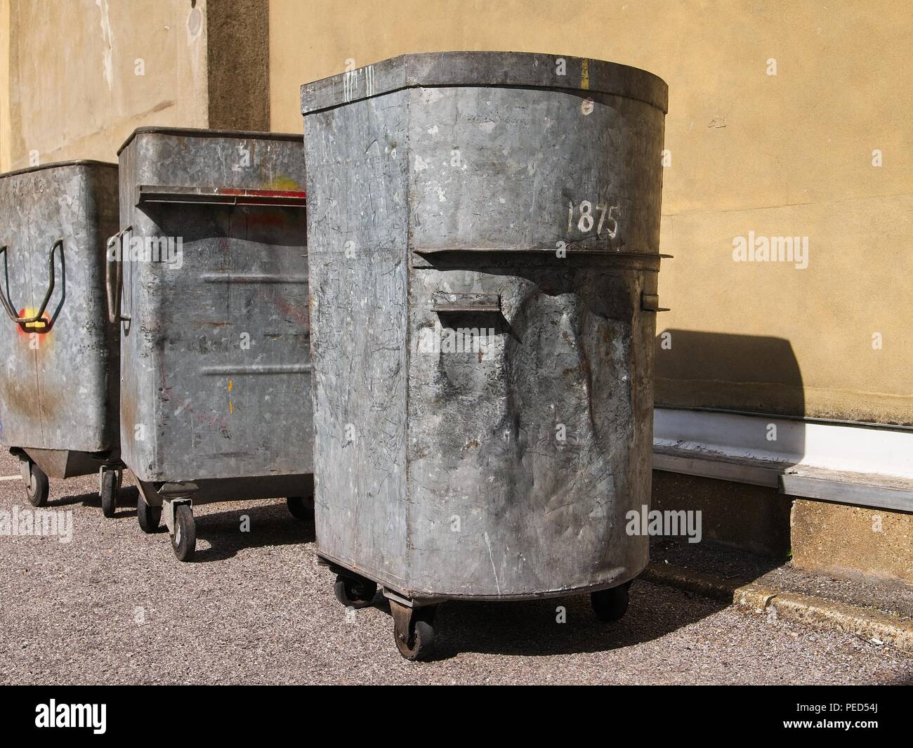Vuoto stagno grandi contenitori per rifiuti in una fila su un soleggiato strada urbana.immagine della città urbana. Foto Stock