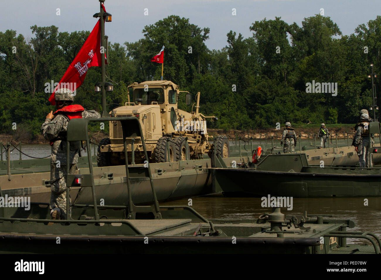 Ponte di membri di equipaggio con l'Ingegnere 502nd Company (Ponte Multi-Rolled Company), e l'Ingegnere 712th Company (orizzontale), da Fort Knox, Ky., guidare una livellatrice di massa su completato ponte sul fiume Arkansas durante il divario della formazione a Fort Chaffee, arca. agosto 4. L'intero esercizio durò dal 28 luglio al 7 agosto, 2015, coinvolgendo un quartier generale di brigata, due battaglioni e 17 altre unità, per includere il bridging, Sapper, la mobilità, la costruzione e le compagnie aeree. (U.S. Esercito foto di Sgt. Jeff Shackelford) Foto Stock