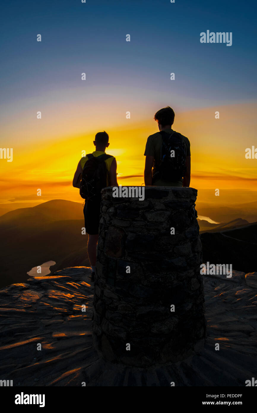 Il vertice di Snowdon - due escursionisti godendo la vista al tramonto. Foto Stock