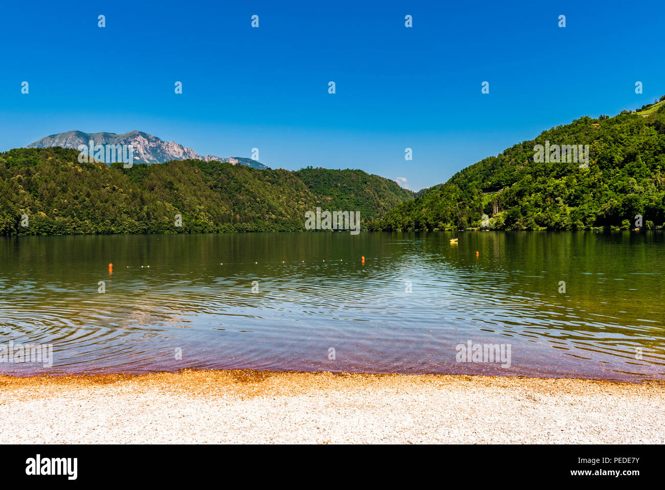 Il lago, le montagne e la spiaggia a Levico Terme, Trentino, Italia Foto Stock