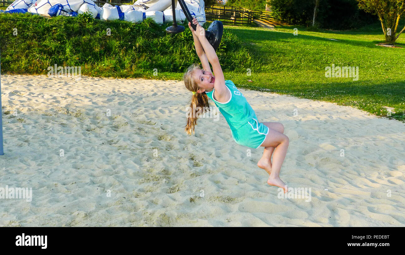 Bambino, ragazza, bambino, oscillare su una corda, concetto di gioia, concetto felice, parco giochi, vita migliore, giocare nella sabbia Normandia, Francia Foto Stock