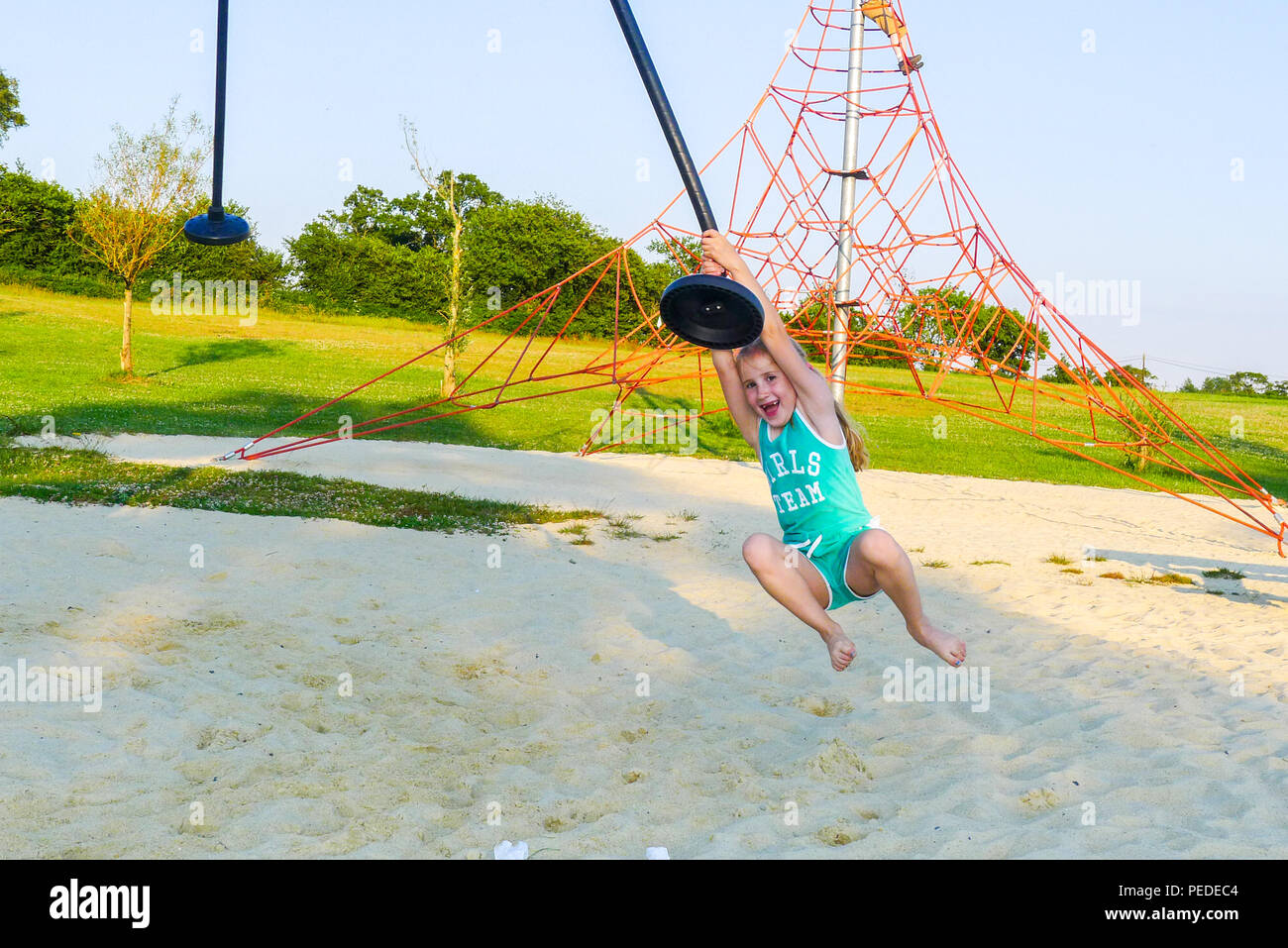 Bambino, ragazza, capretto, oscillanti su una fune, gioia concetto, felice concetto, parco giochi, Normandia, Francia Foto Stock
