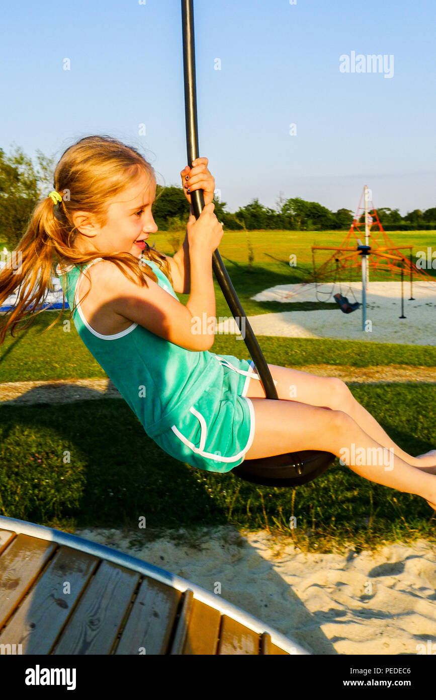 Bambino, ragazza, capretto, oscillanti su una fune, gioia concetto, felice concetto, parco giochi, Normandia, Francia Foto Stock