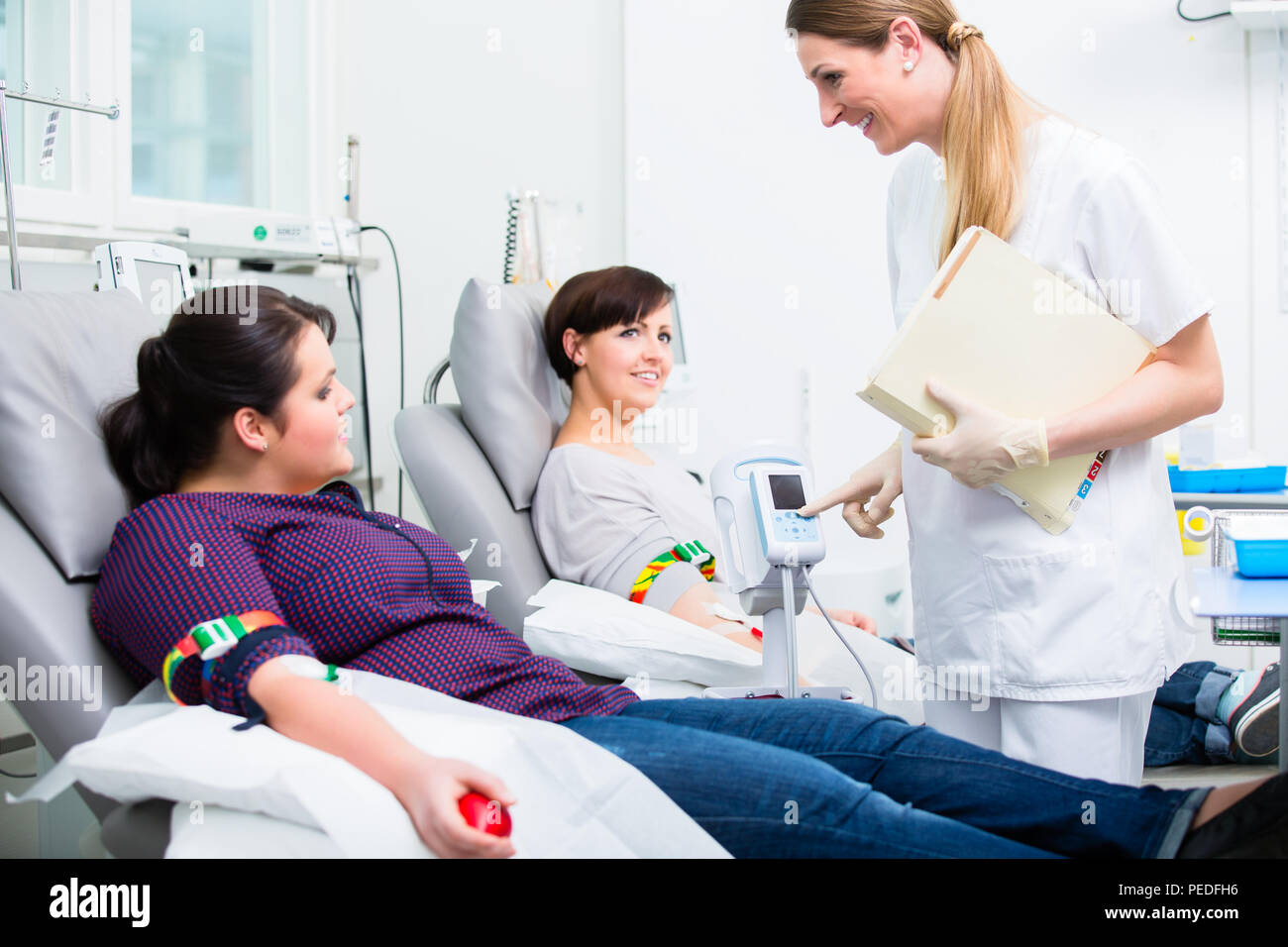 Assistente di medici la raccolta di donazioni di sangue Foto Stock