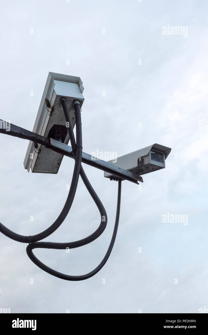 Due videocamere di sicurezza rivolte in direzioni differenti su un braccio metallico Foto Stock