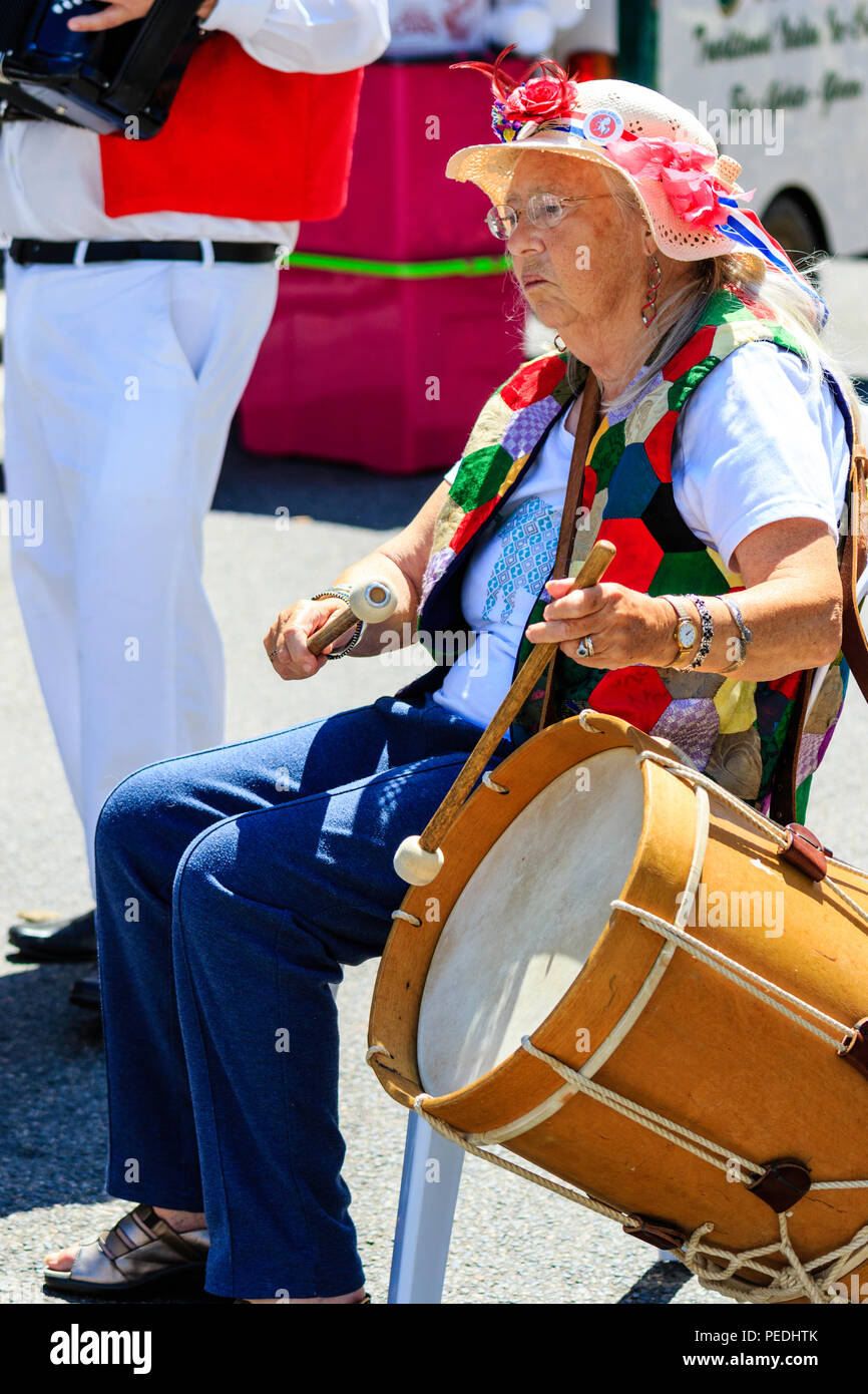 Folk tradizionale musicista, senior lady, 70s, seduta in costume di morris drumming con il lato esterno del tamburo a sandwich e Folk Ale evento. Foto Stock