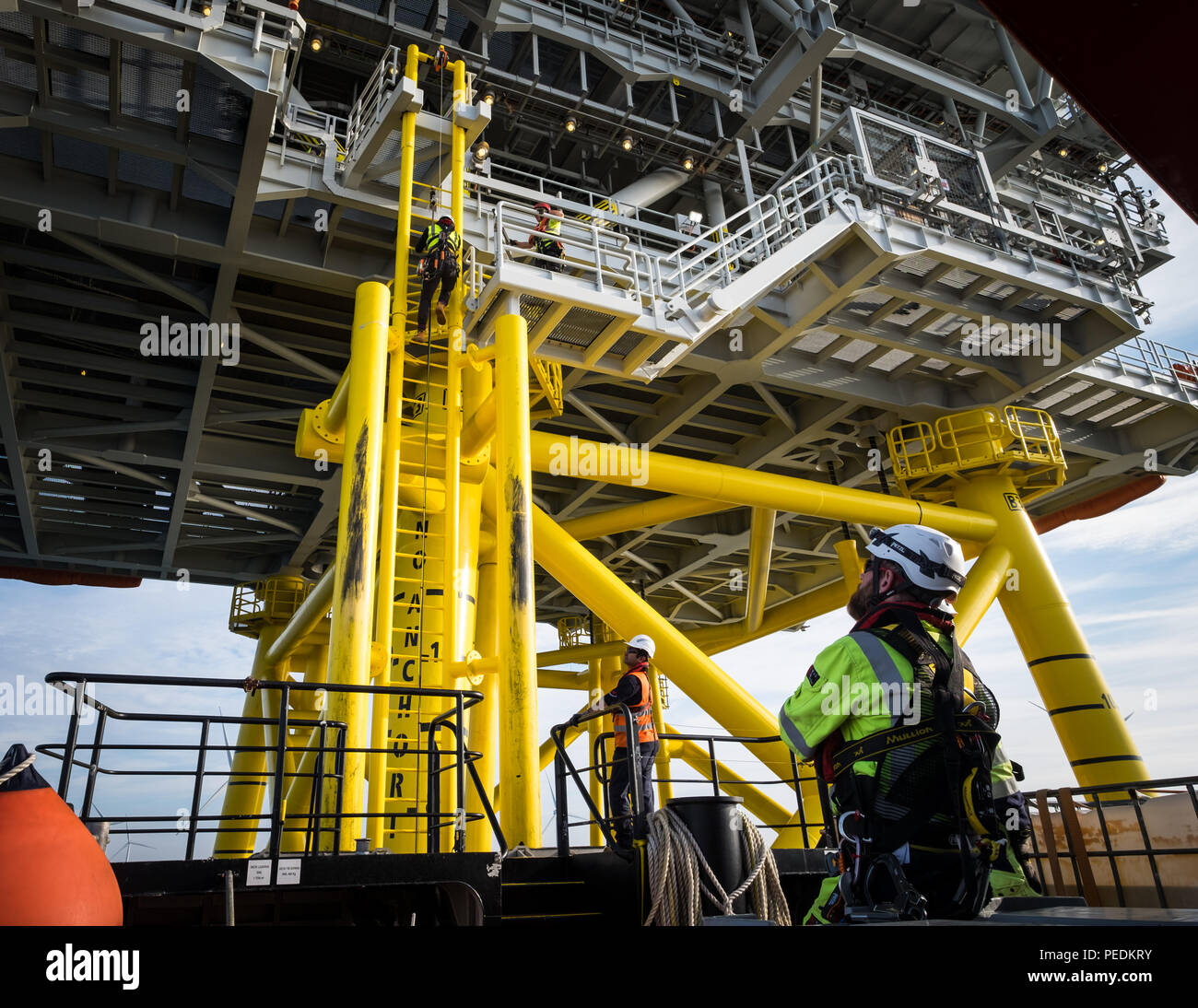 Un lavoratore di arrampicata sottostazione Offshore (OSS) Z02 sulla banca di Gara Offshore Wind Farm nella parte meridionale del Mare del Nord Regno Unito Foto Stock