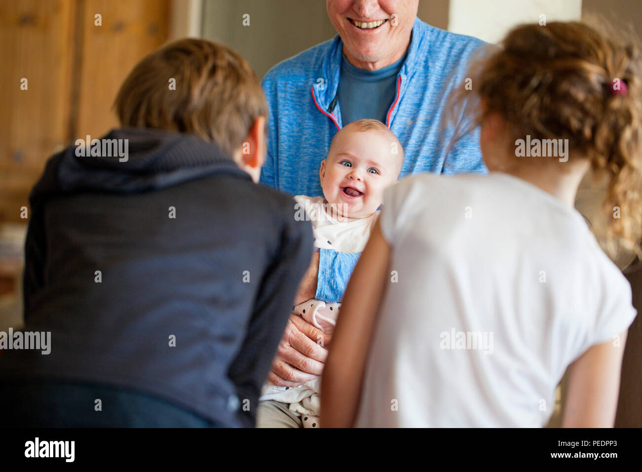 Baby girl essendo intrattenuti da bambini piccoli Foto Stock