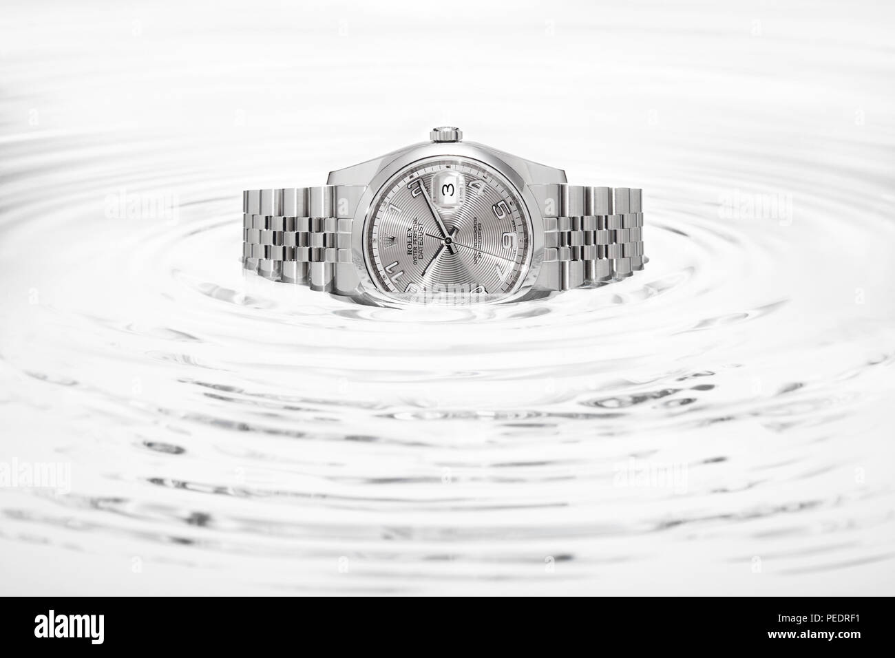 Rolex Datejust 36mm su cerchi concentrici di acqua nera Foto stock - Alamy