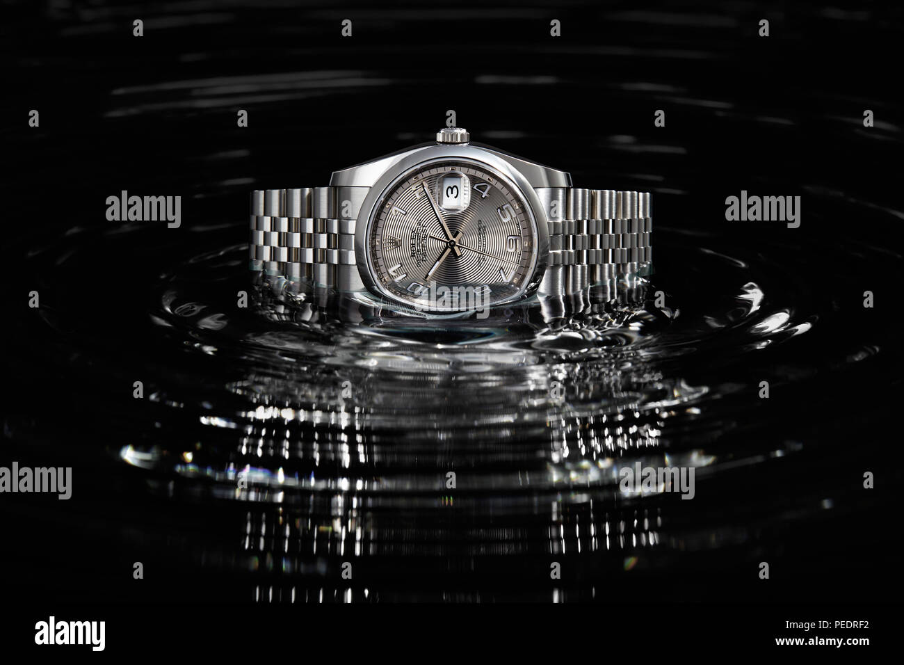 Rolex Datejust 36mm su cerchi concentrici di acqua nera Foto stock - Alamy