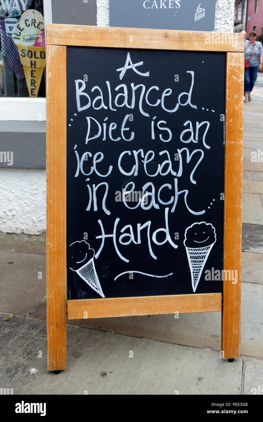 Pubblicità lavagna con divertente messaggio circa una dieta equilibrata e mangiare il gelato al di fuori di un negozio a South Queensferry, Scozia Foto Stock