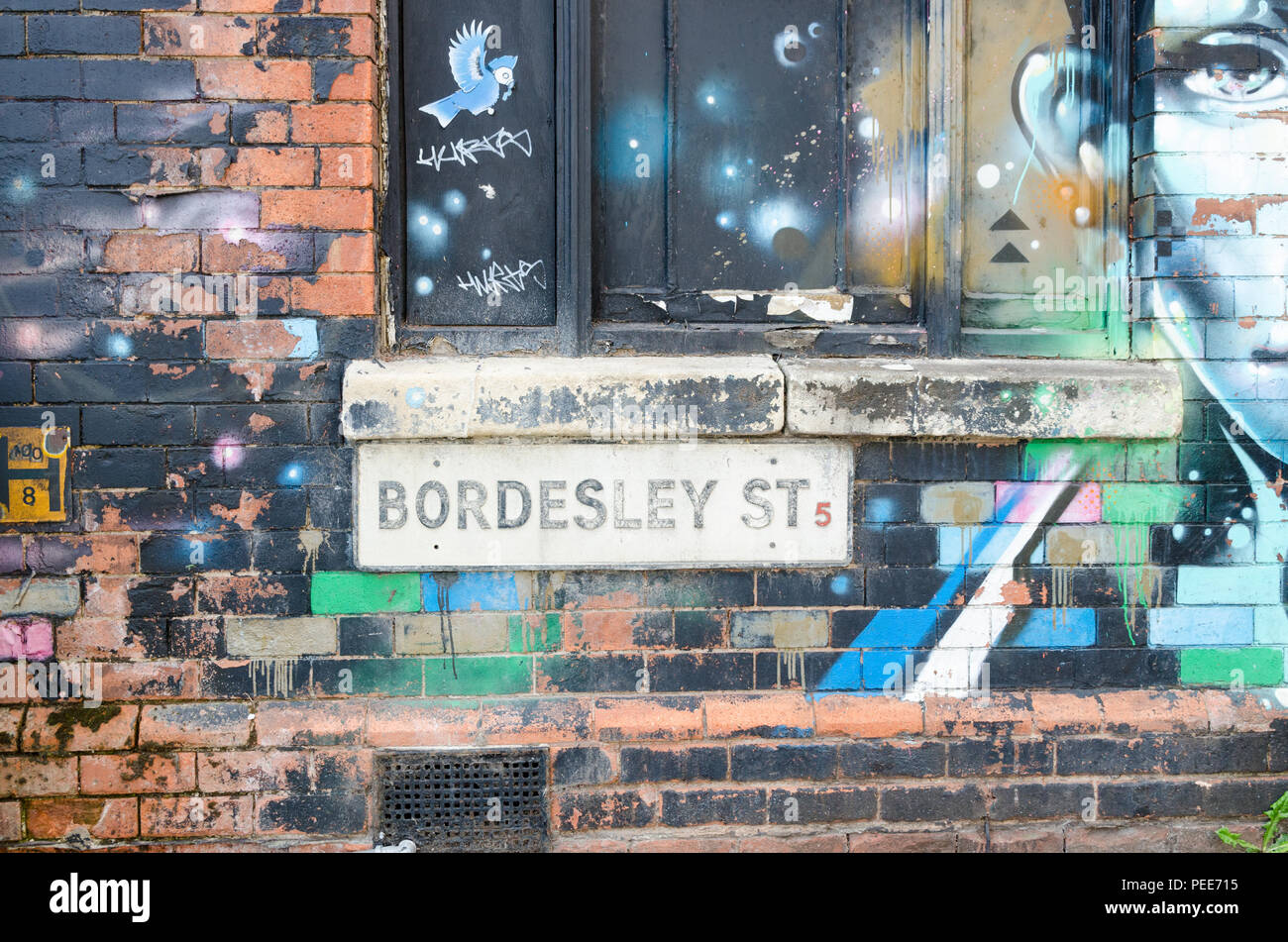 Parete di edificio abbandonato in Bordesley Street, Digbeth, Birmingham decorata da graffiti artist Foto Stock