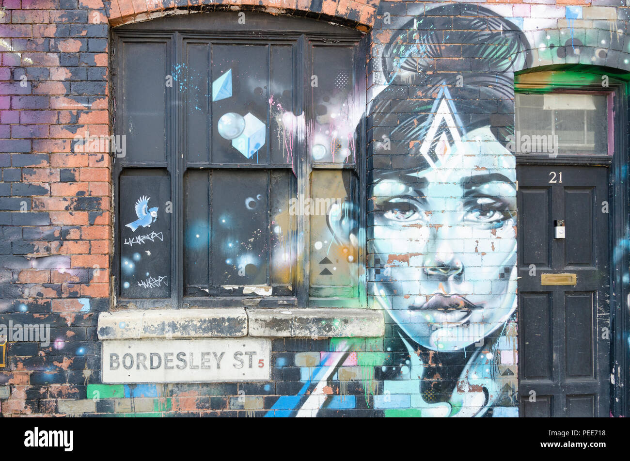 Parete di edificio abbandonato in Bordesley Street, Digbeth, Birmingham decorata da graffiti artist Foto Stock
