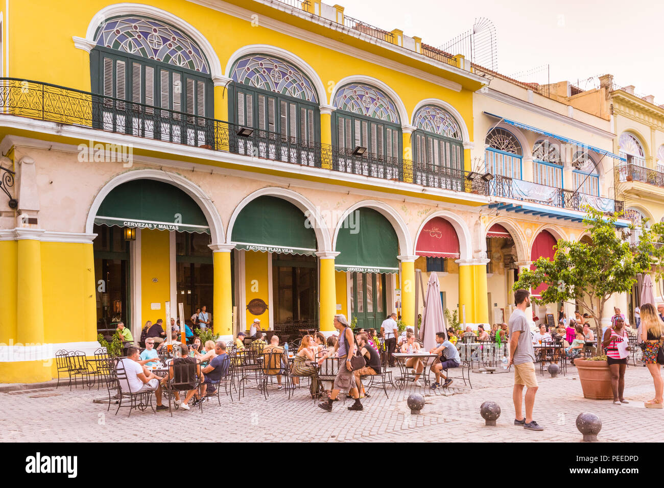 La gente nei caffè e ristoranti su Plaza Vieja, Old Havana, Cuba Foto Stock