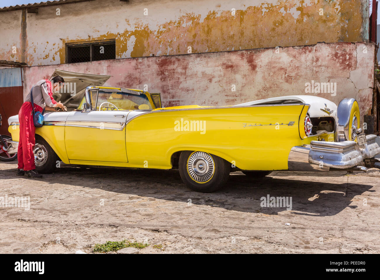1957 Ford Fairlane 500 Skyliner convertibile in giallo, American classic car, meccanico esegue la riparazione e la manutenzione presso un garage a l'Avana, Cuba Foto Stock