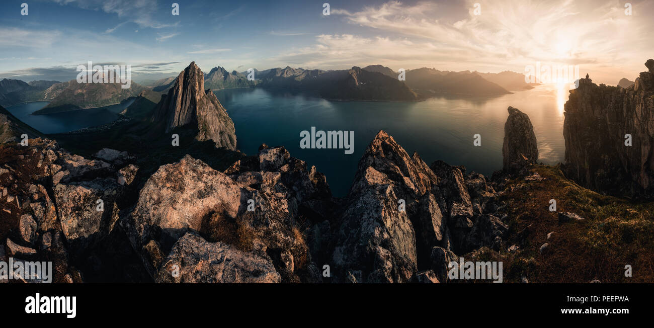 Montuoso panorma vista orizzontale con enormi fiordi durante il tramonto dorato in Senja, Norvegia Foto Stock
