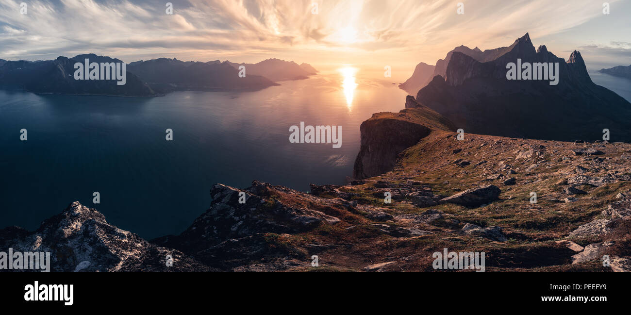 Montuoso panorma vista orizzontale con enormi fiordi durante il tramonto dorato in Senja, Norvegia Foto Stock