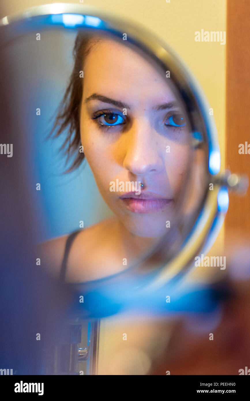 Donna che guarda nello specchio che compongono Foto Stock