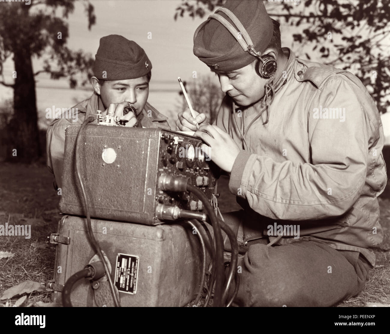 Codice Navajo talker cugini PFC Preston Toledo e PFC Frank Toledo, attaccato ad un Marine Reggimento di Artiglieria nel Pacifico del Sud durante la II Guerra Mondiale, utilizzare un campo radio per trasmettere gli ordini nella loro nativa lingua Navajo. Foto: Luglio 7, 1943. Foto Stock