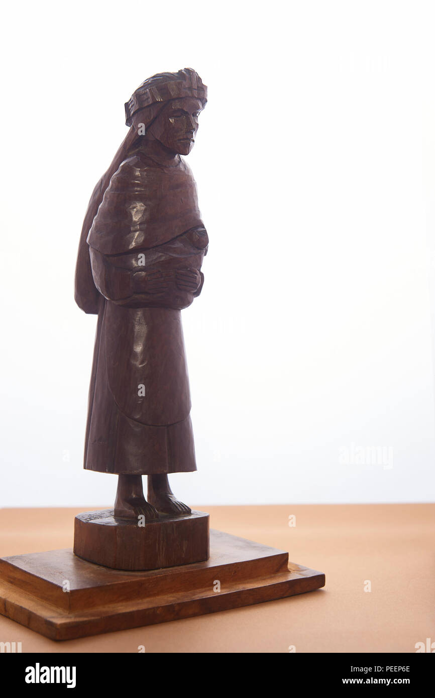 Piccole casette di legno che la figura di donna indigena che porta un bambino Foto Stock