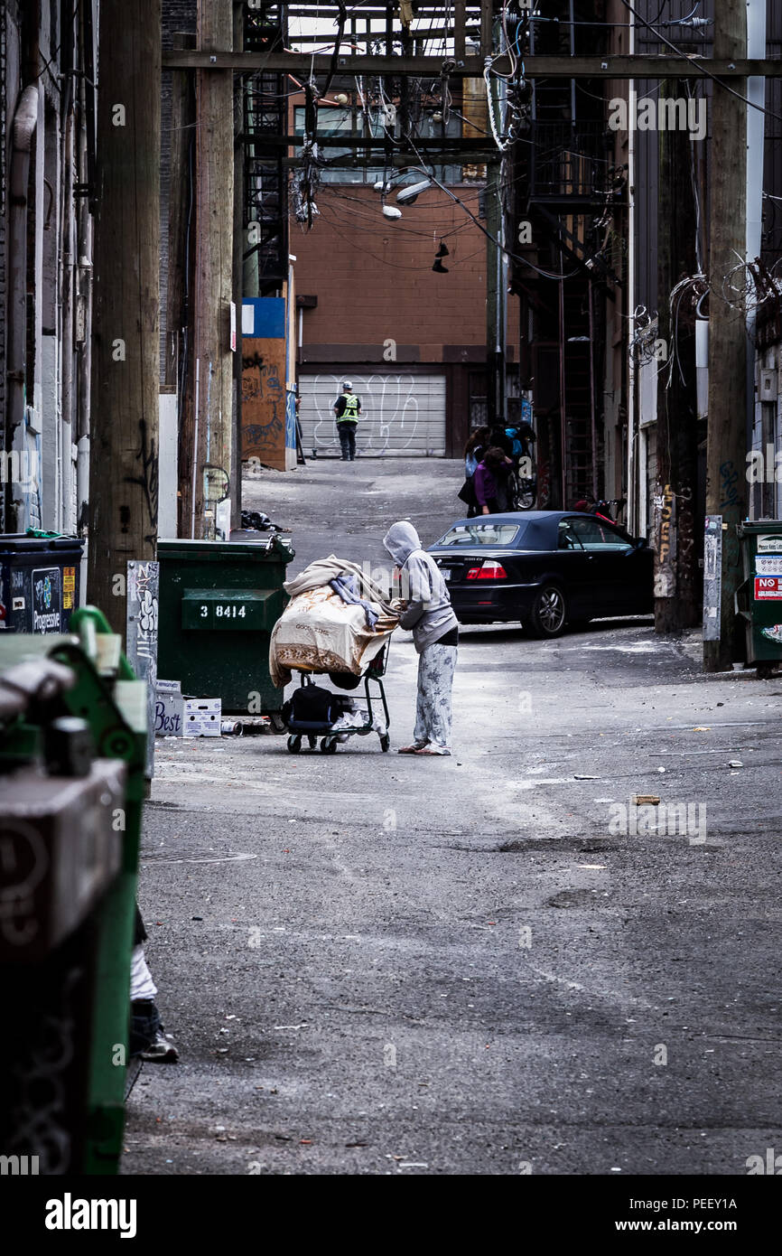 VANCOUVER, BC, Canada - 11 Maggio 2016: un vagabondo con un carrello di shopping in Vancouver Downtown Eastside. Foto Stock