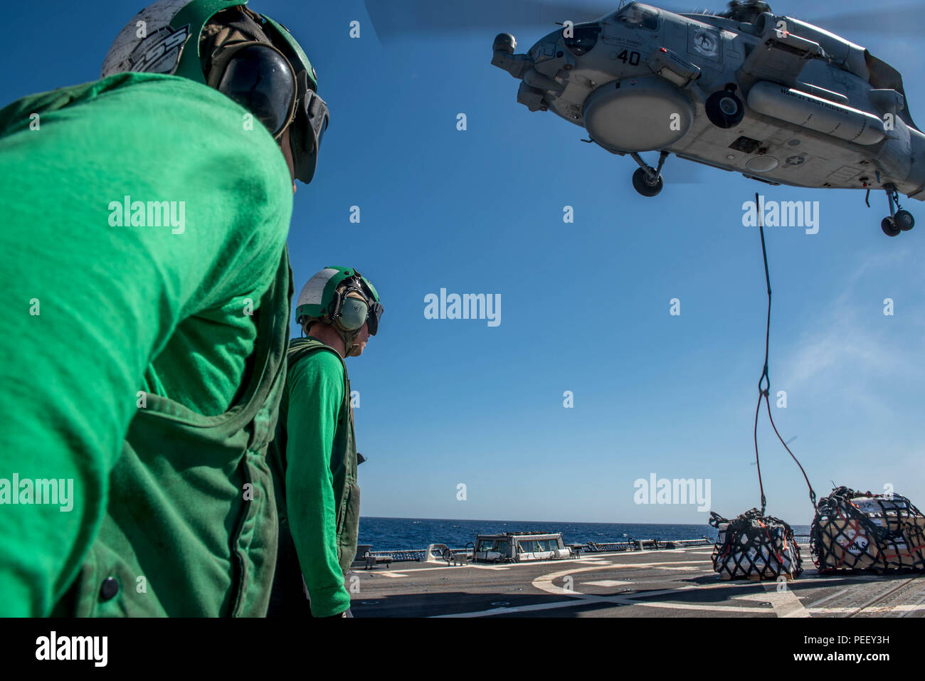 150812-N-MJ645-336 OCEANO PACIFICO (Agosto 12, 2015) - Un MH-60R Sea Hawk dalla Paniolo di elicottero sciopero marittimo Squadron (HSM-37) scarica forniture durante un rifornimento verticale (VERTREP) sul bordo guidato-missile destroyer USS Chung-Hoon (DDG 93). I marinai del Chung-Hoon sono sottoposti a formazione composita dell'Unità Esercizio e Joint Task Force Esercizio (COMPTUEX/JTFEX), la fase finale nella certificazione di distribuire. (U.S. Foto di Marina di Massa lo specialista di comunicazione 2a classe Marcus L. Stanley/rilasciato) Foto Stock