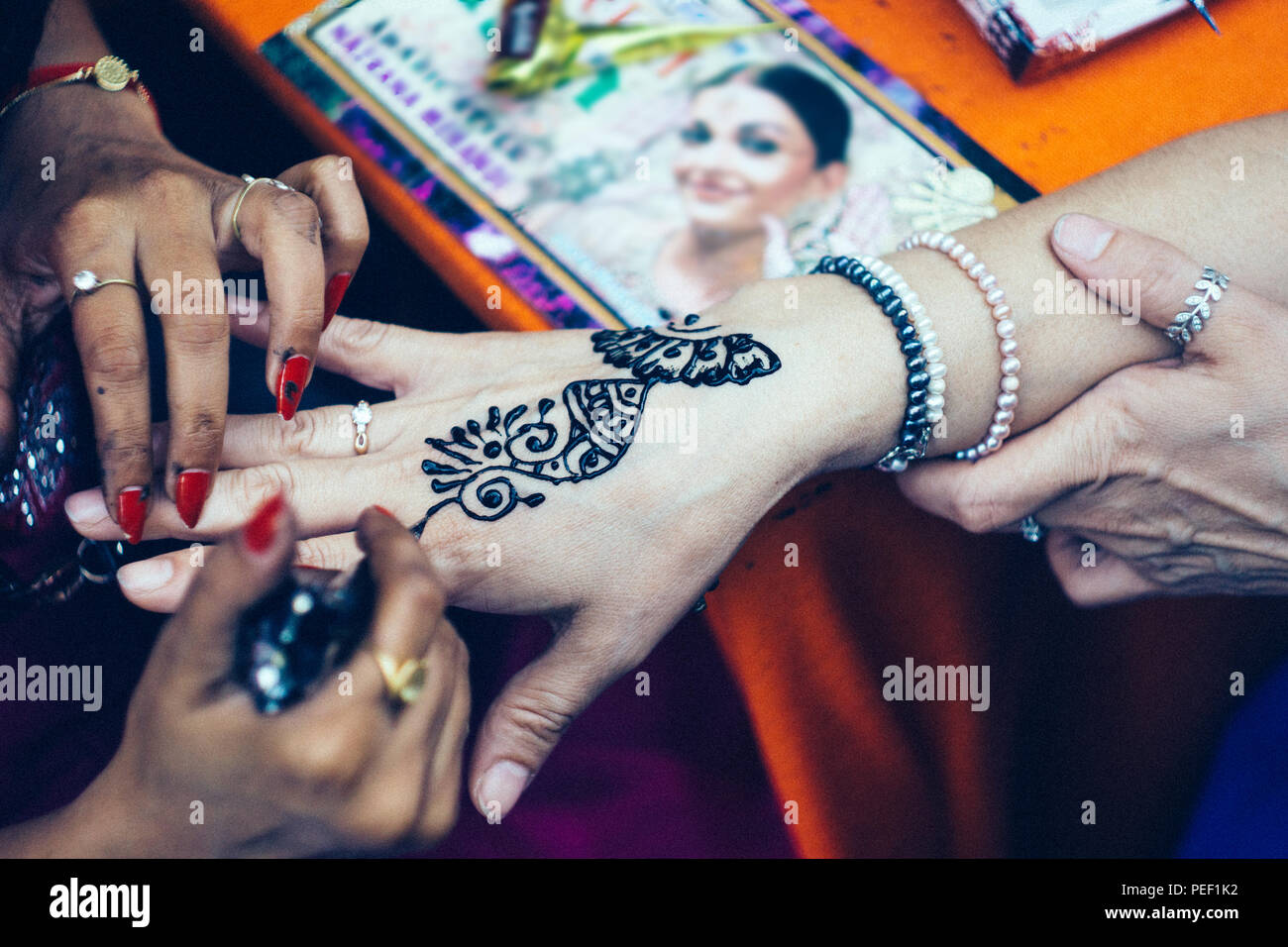 Donna artista mehendi pittura henna sulla donna mano Foto Stock