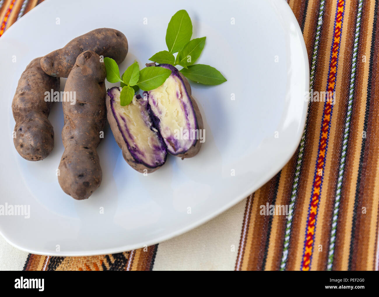 Appena sfornato patate viola su una piastra bianca. Patate di Chiloe Foto Stock